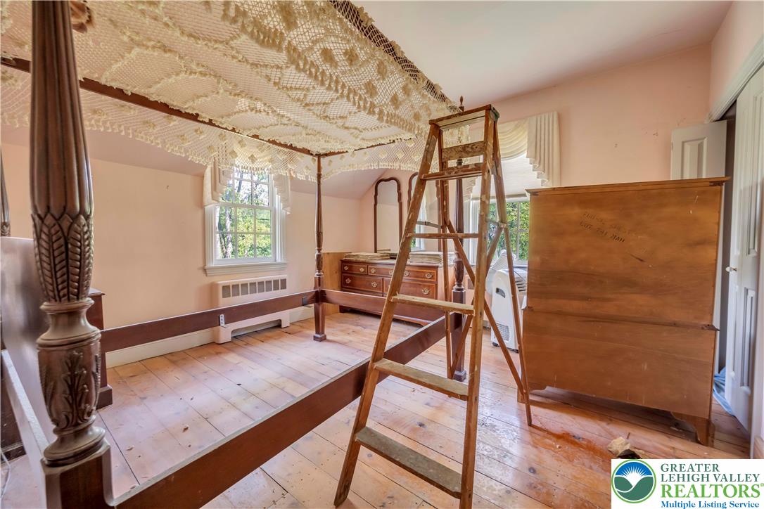 384 Henry Road Nazareth, PA 18064 - Photo 43 of 54 Warm wide-plank wood floors and classic multi-pane windows anchor this charming bedroom space.
