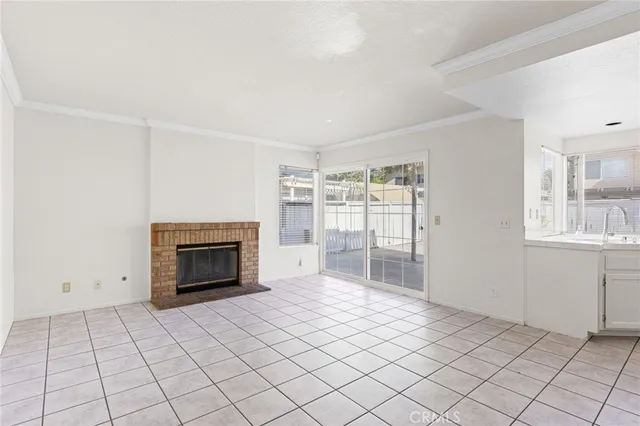 a view of an empty room with a fireplace and a window