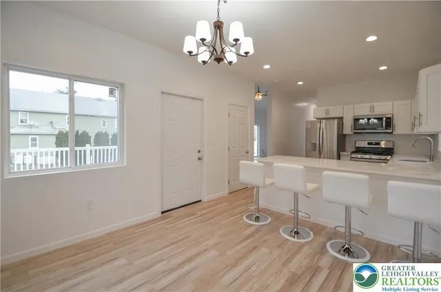 a view of a kitchen with granite countertop wooden floor and stainless steel appliances