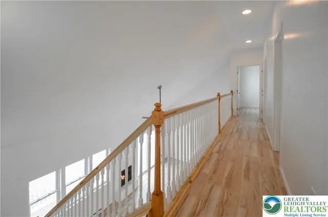 a view of a hallway with wooden floor and stairs