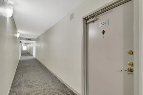 a living room with furniture a rug and a floor to ceiling window