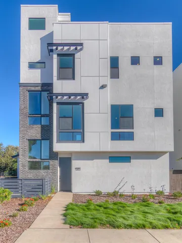 a view of a building with a yard and large tree