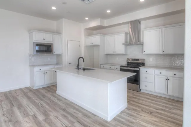 a kitchen with cabinets appliances and a wooden floor