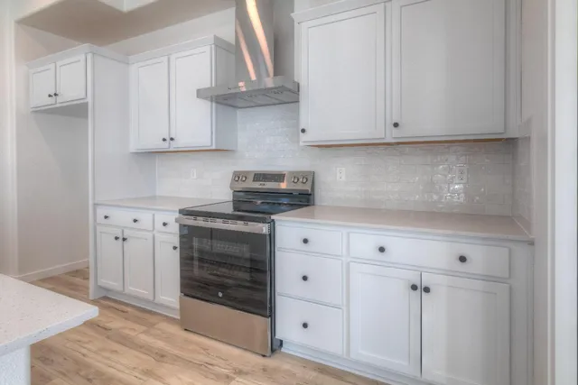 a kitchen with white cabinets and a stove