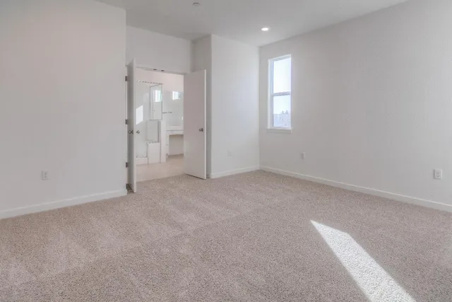 an empty room with windows and bathroom