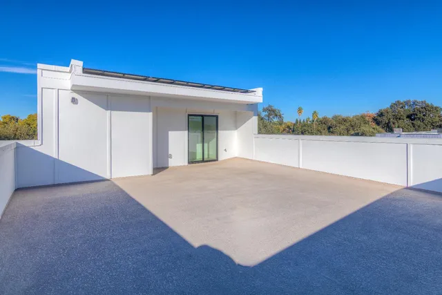 a view of a white house with a yard and large tree