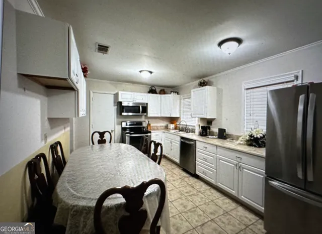 a kitchen with refrigerator cabinets dining table and chairs