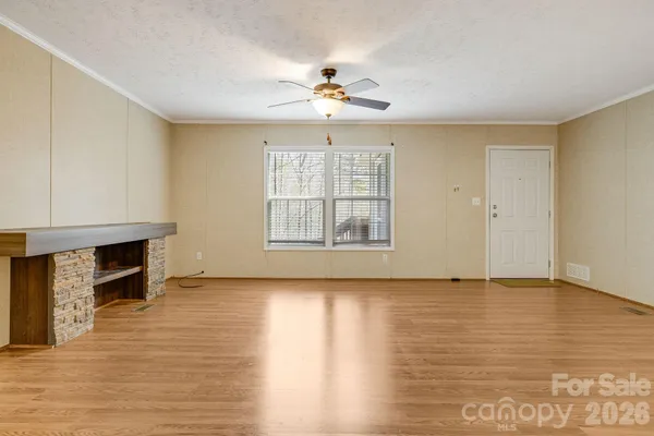 an empty room with windows fireplace and windows