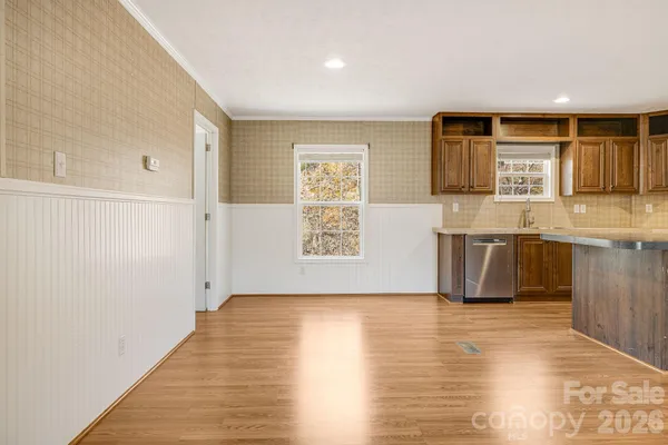 a view of a kitchen with stainless steel appliances wooden floor and a large window
