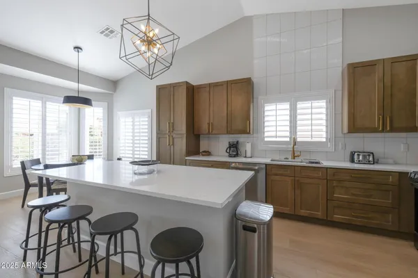 a kitchen with kitchen island a dining table chairs and white cabinets