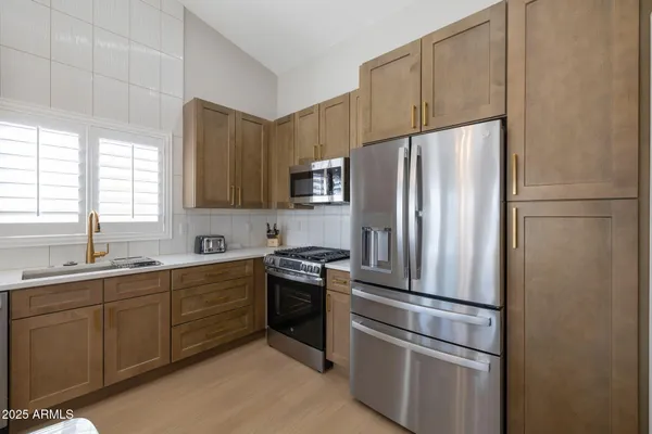 a kitchen with a dining table chairs sink and cabinets