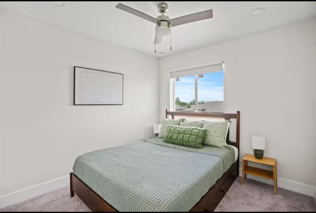 1547 West 26th Court Riviera Beach, FL 33404 - Photo 14 of 18 a bedroom with a bed and a lamp