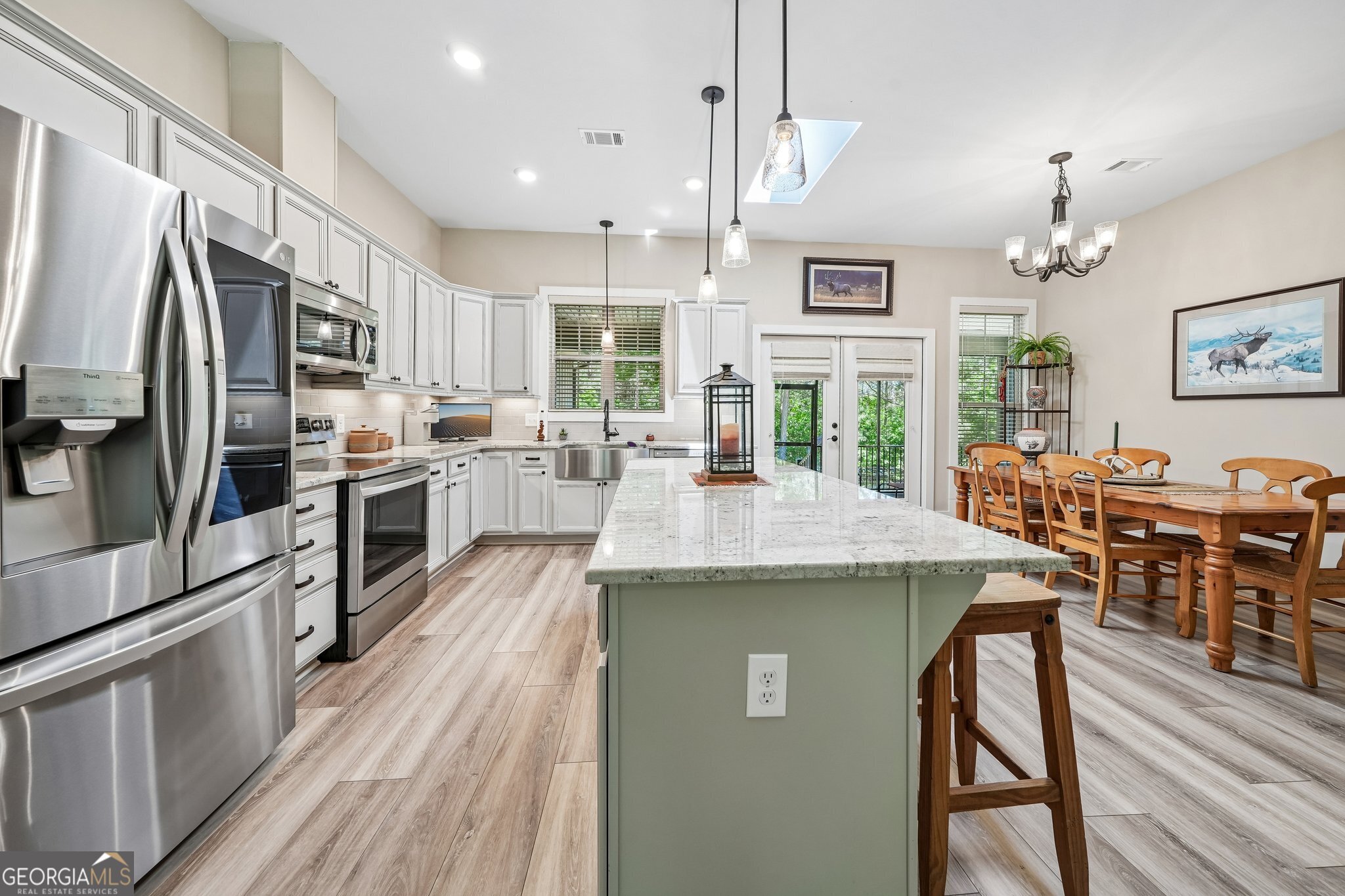 108 Wilderness Way Jackson, GA 30233 - Photo 15 of 31 a kitchen with stainless steel appliances granite countertop a stove a refrigerator a kitchen island a dining table and chairs with wooden floor
