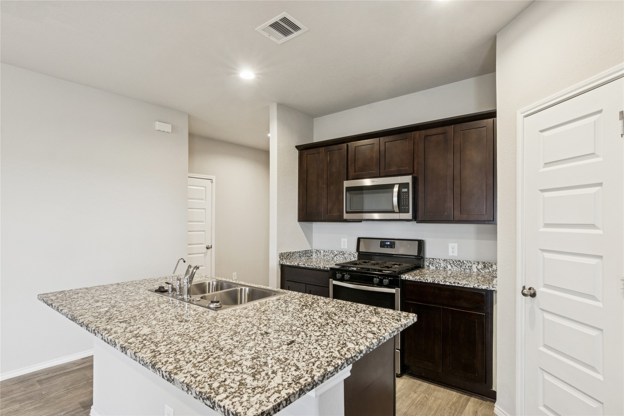 1603 Goose Island Lane Rosenberg, TX 77469 - Photo 11 of 26 a kitchen with kitchen island granite countertop a sink stove and refrigerator