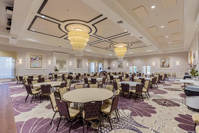 a room with lots of chairs a large window and chairs