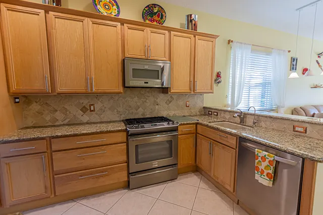 a kitchen with stainless steel appliances granite countertop a sink and a microwave
