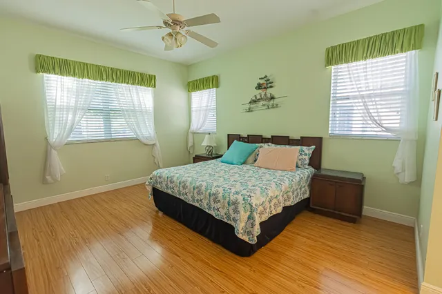 a bedroom with a bed wooden floor and window