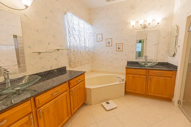 a spacious bathroom with a granite countertop sink a toilet a mirror and bathtub
