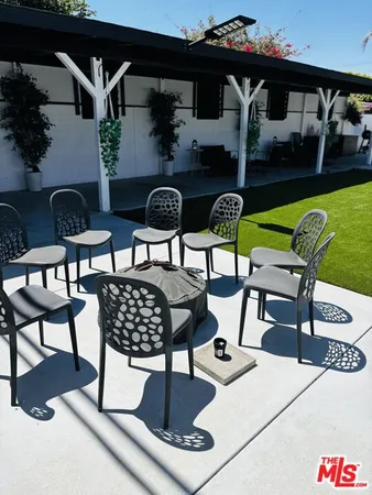 a view of a patio with table and chairs barbeque potted plants