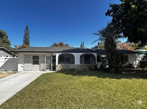 a front view of a house with yard and trees