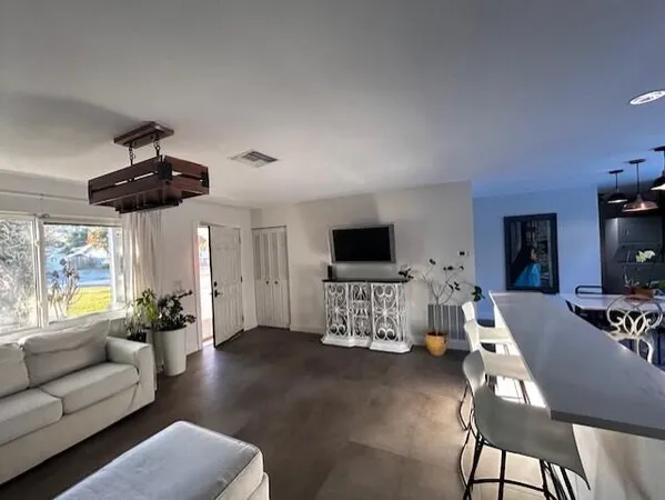 a kitchen with stainless steel appliances granite countertop a stove a refrigerator a kitchen island a table and chairs