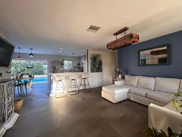 a bed sitting in a spacious bedroom next to a window