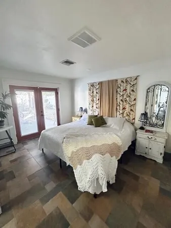 a bedroom with a bed and a large mirror