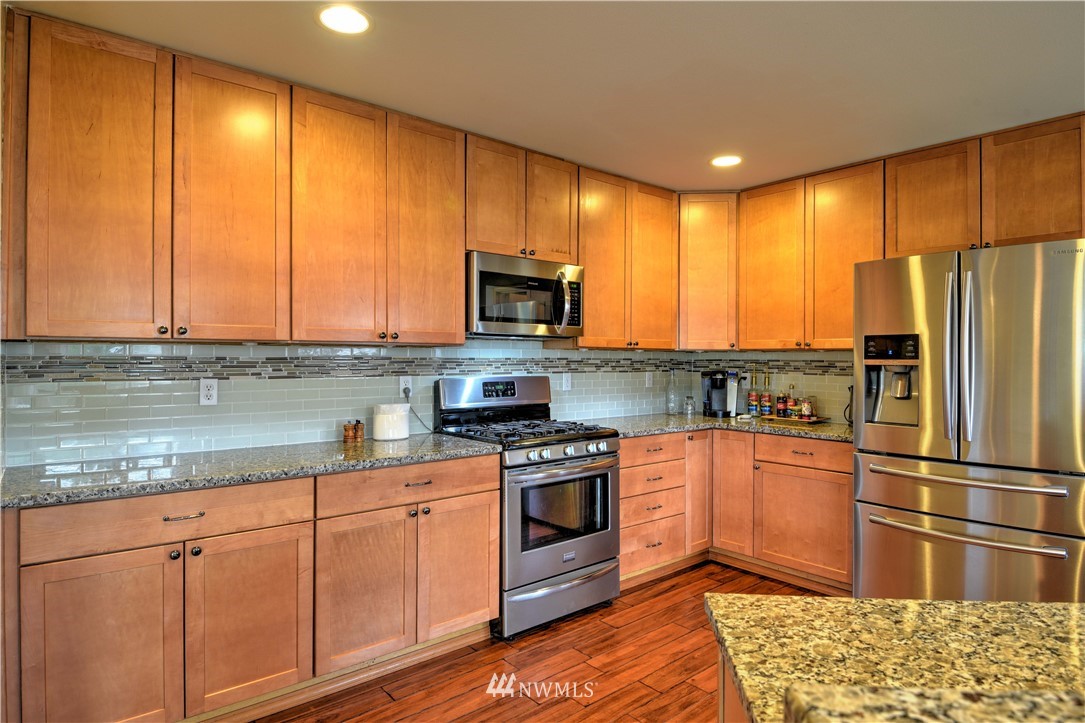20398 Springbrook Road Southeast Monroe, WA 98272 - Photo 3 of 39 a kitchen with stainless steel appliances granite countertop a stove a sink and a microwave