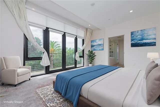 a bedroom with a bed and a large window