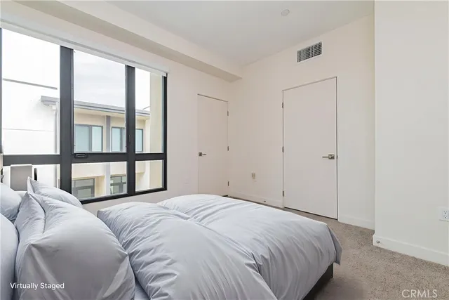 a bedroom with a large bed and a large window