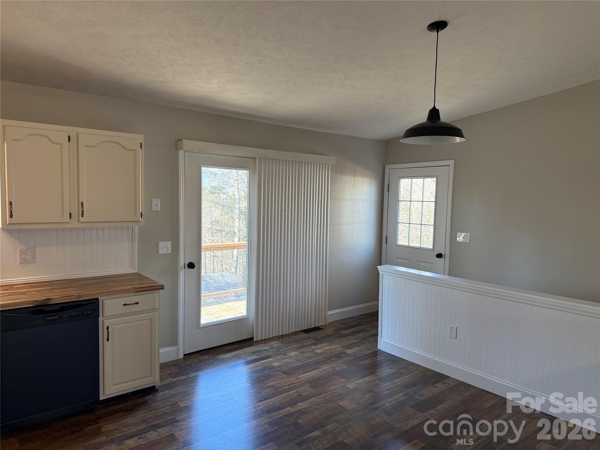628 Hidden View Loop Marion, NC 28752 - Photo 11 of 44 a view of a kitchen and an empty room with wooden floor and windows