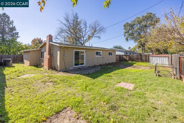 a backyard of a house with table and chairs