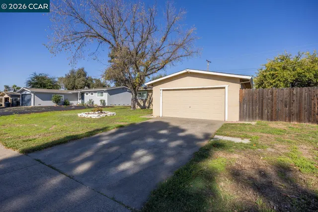 a view of a house with a yard and a garage