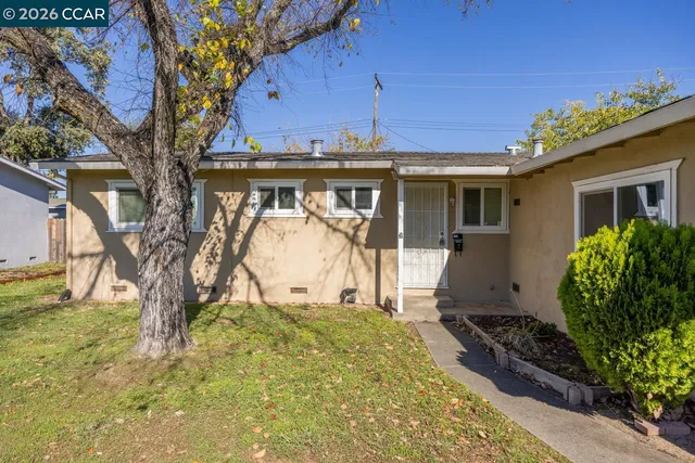 a view of a house with a large tree and a yard