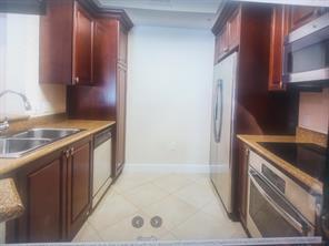 1690 Renaissance Commons Boulevard, Unit 1623 Boynton Beach, FL 33426 - Photo 3 of 9 a kitchen with granite countertop a sink and a stove