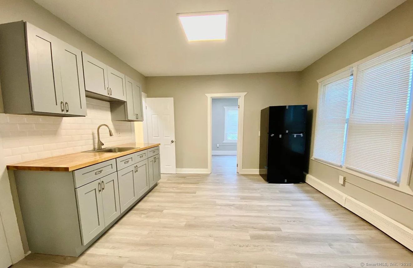 a kitchen with granite countertop a refrigerator and a sink