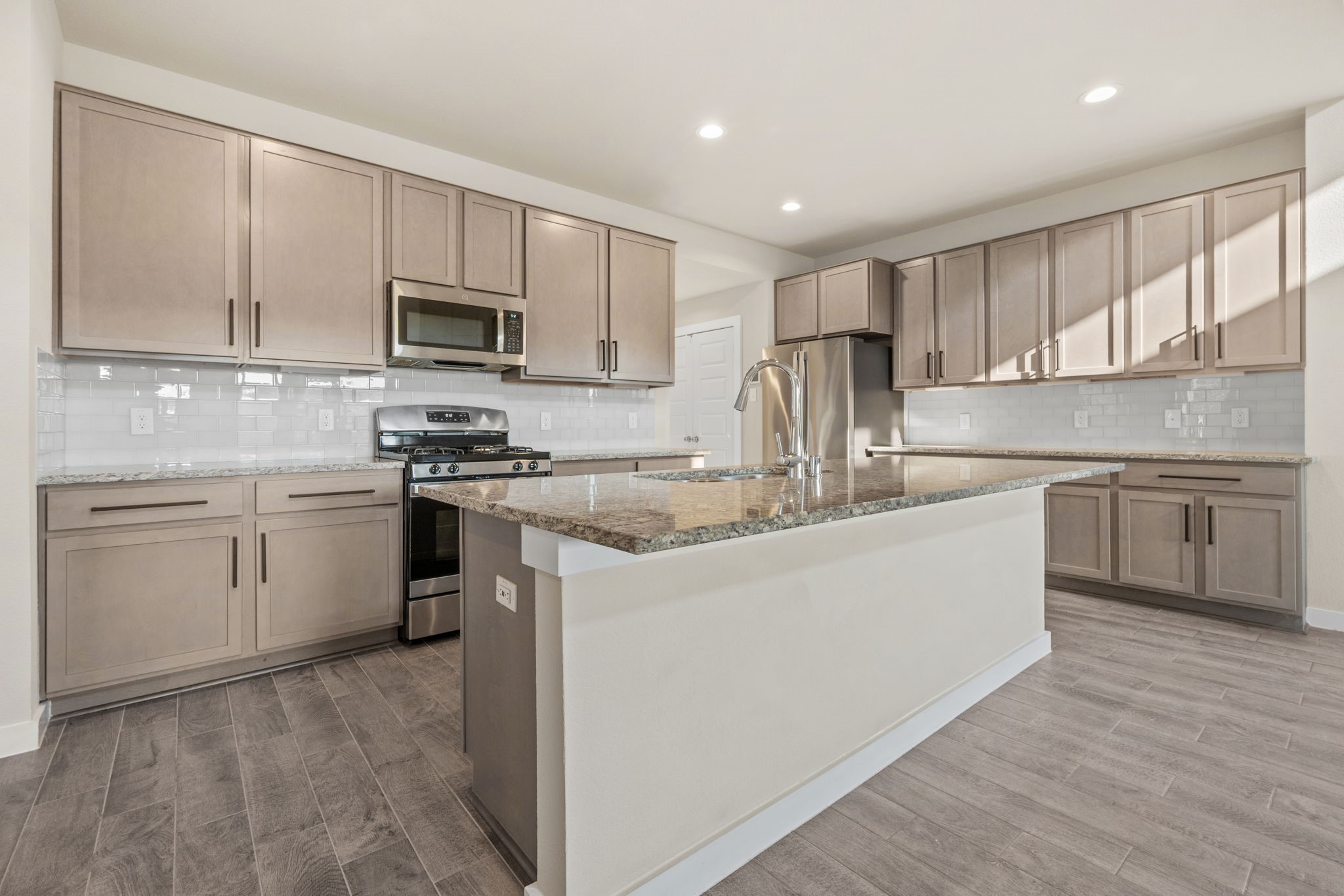15666 Countesswells Drive Humble, TX 77346 - Photo 2 of 32 a kitchen with stainless steel appliances granite countertop a stove top oven a sink dishwasher and a refrigerator with wooden floor