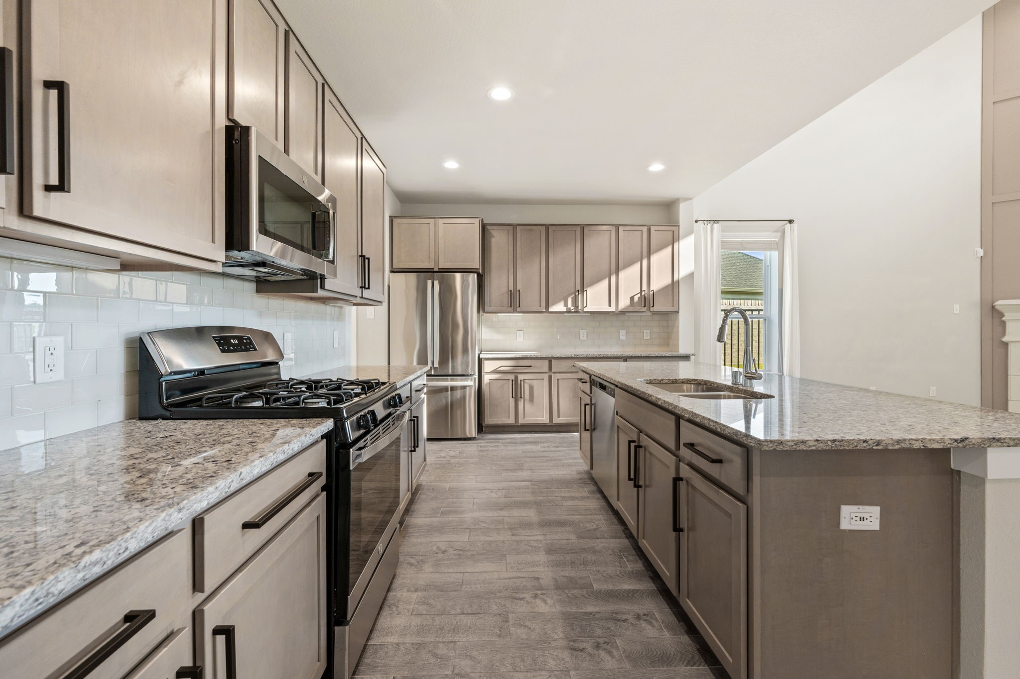 15666 Countesswells Drive Humble, TX 77346 - Photo 3 of 32 a kitchen with stainless steel appliances granite countertop a stove top oven a sink and dishwasher