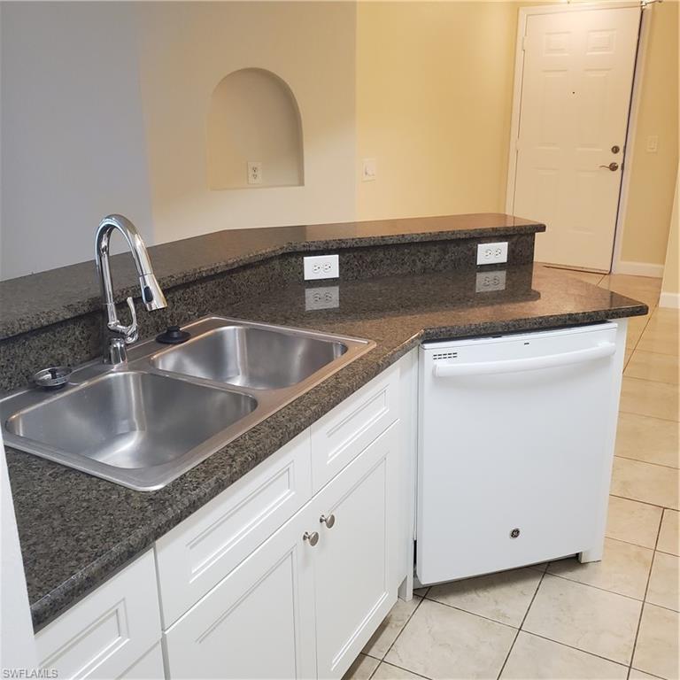 12980 Positano Circle, Unit 207 Naples, FL 34105 - Photo 7 of 23 a kitchen with sink and white cabinet
