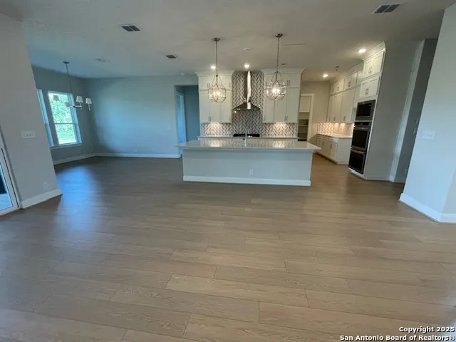 a view of kitchen and hall with wooden floor