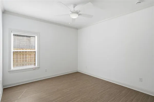 an empty room with a window and ceiling fan
