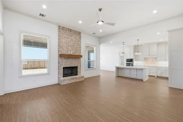 a view of a kitchen with a stove wooden cabinets and a fireplace