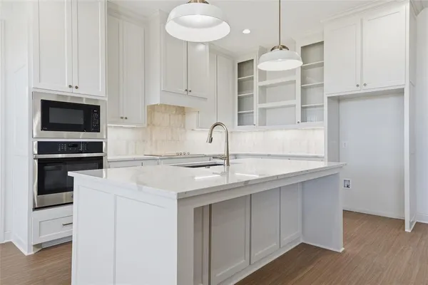 a kitchen with stainless steel appliances granite countertop a sink and cabinets with wooden floor