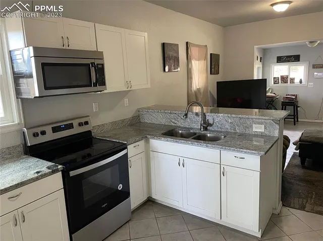 a kitchen with granite countertop a stove and a sink