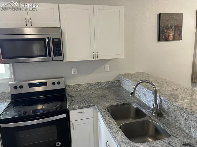 a kitchen with a sink stove and microwave