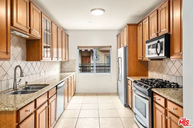 a kitchen with stainless steel appliances granite countertop a stove and a sink