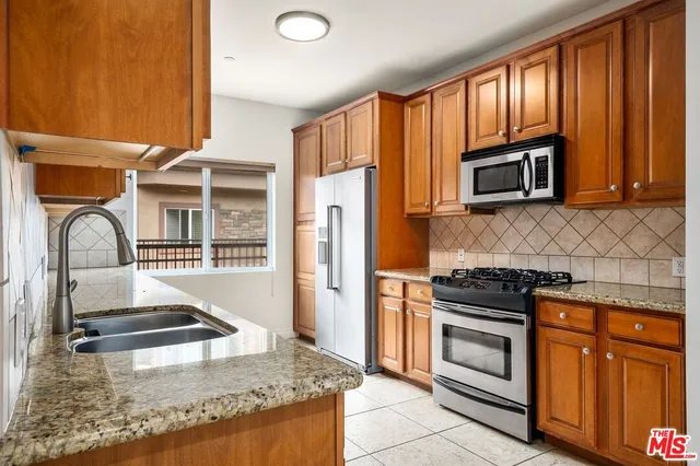 a kitchen with stainless steel appliances granite countertop a stove and a sink