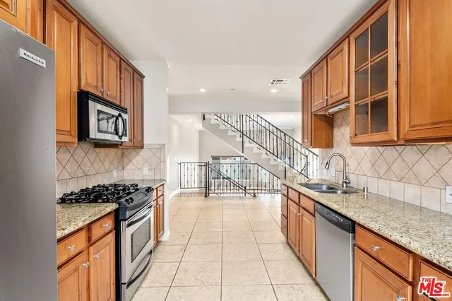 a bathroom with a granite countertop toilet and a sink