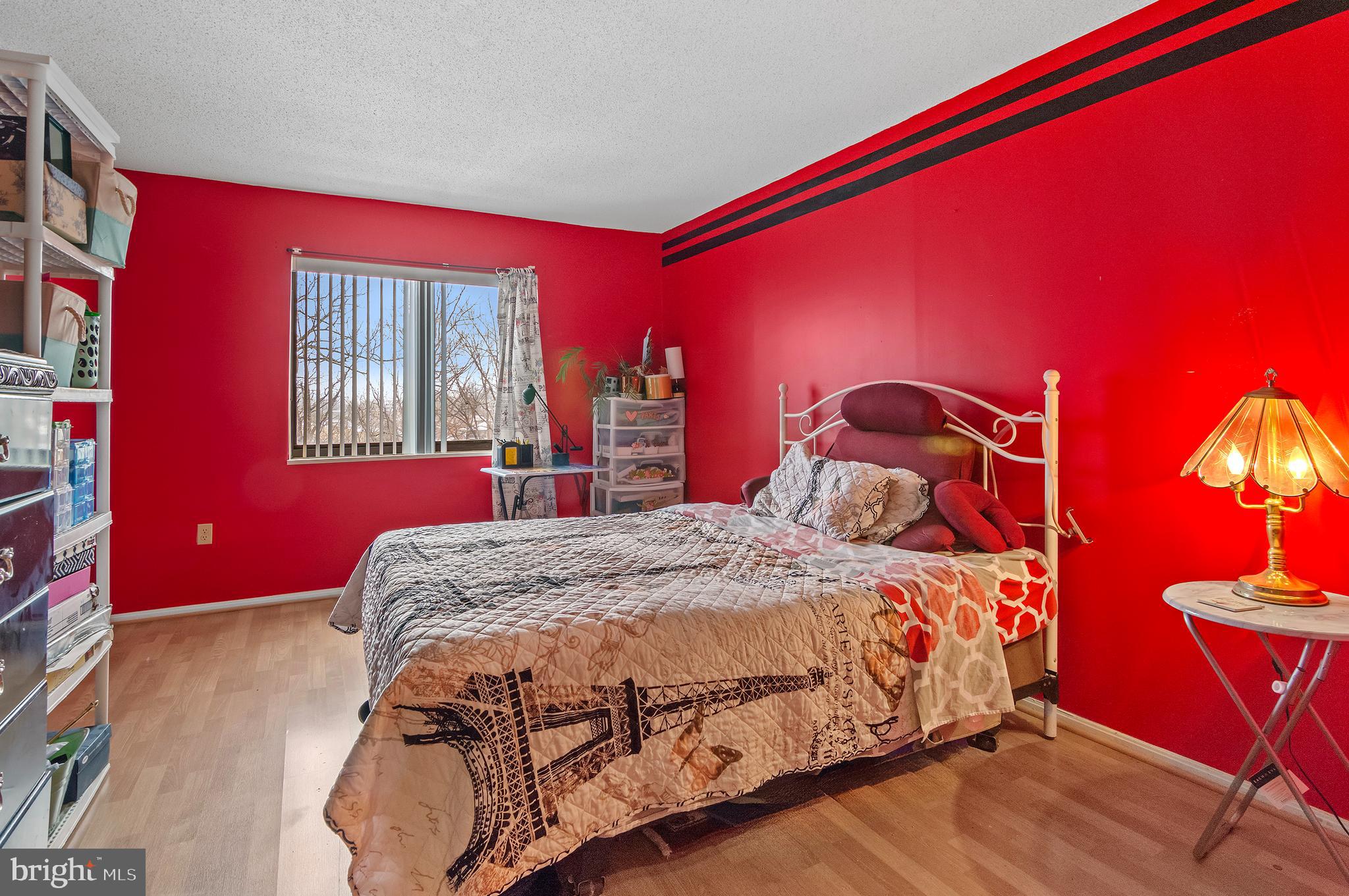 15115 Interlachen Drive, Unit 3506 Silver Spring, MD 20906 - Photo 11 of 27 a bedroom with a bed and a dresser next to a window