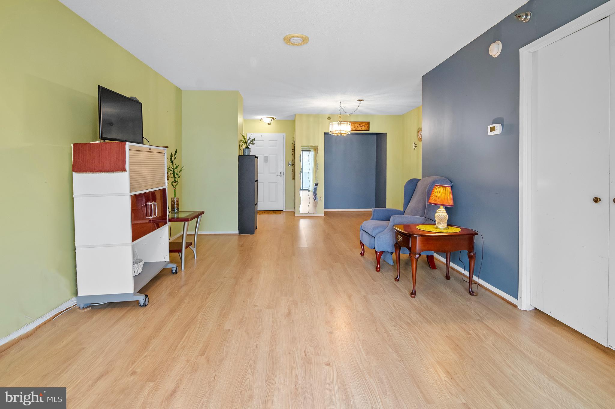 15115 Interlachen Drive, Unit 3506 Silver Spring, MD 20906 - Photo 7 of 27 a living room with furniture and a wooden floor